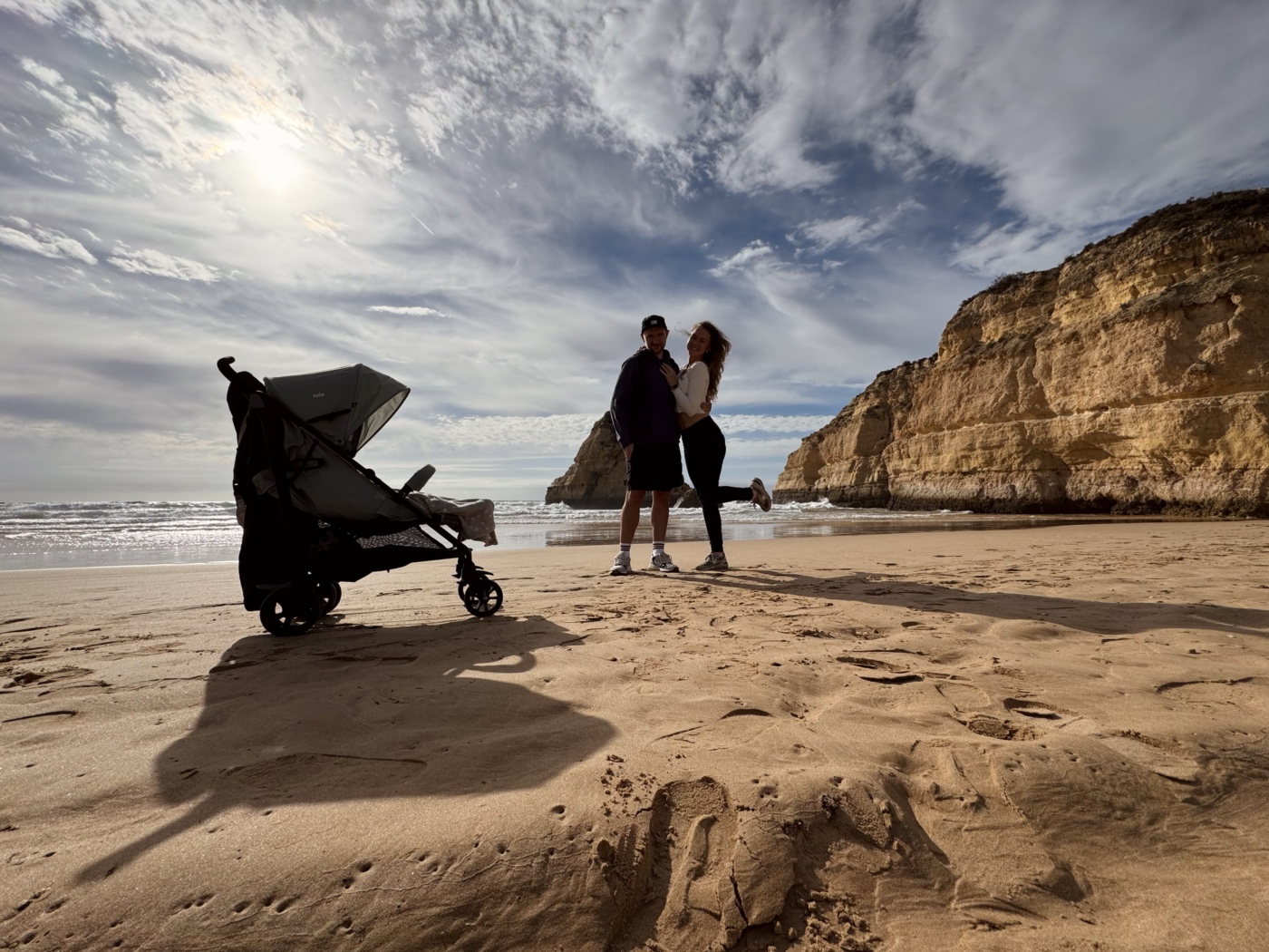 A picture of myself, stading on the beach and smiling.