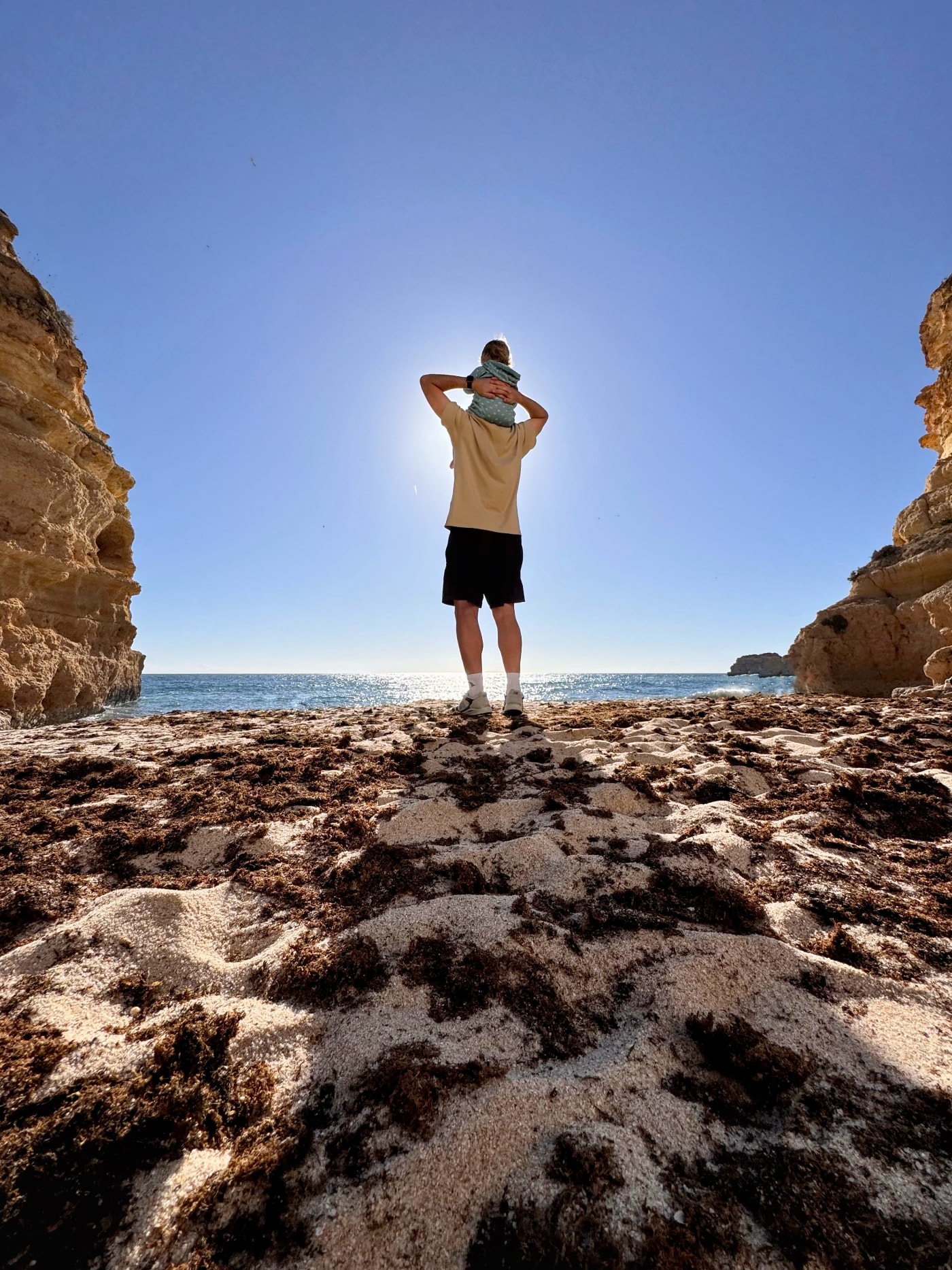 My doughter sitting on my shoulders, and we are both looking at the beautiful view on the beach in the south of Portugal