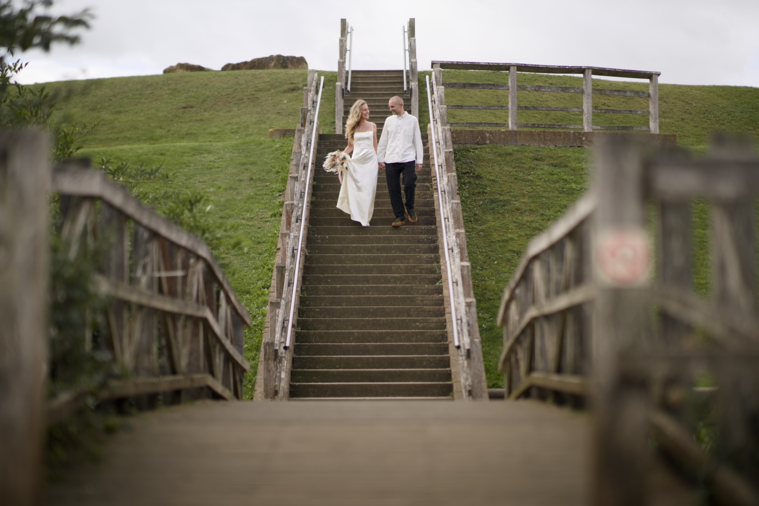 Me and my wife on the wedding day. We are walking down the stairs looking at each other.