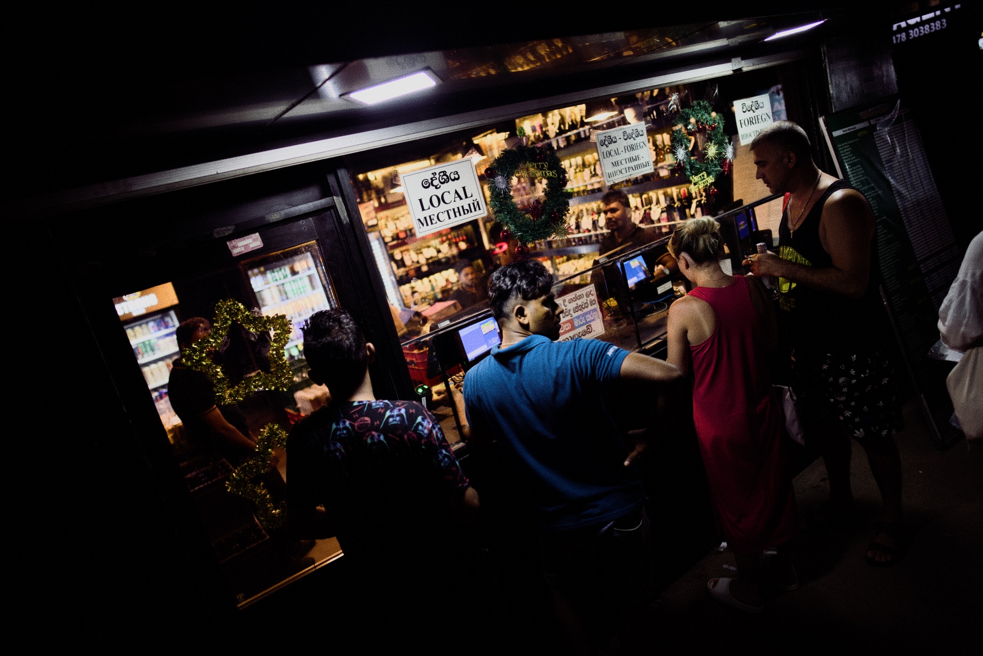 Sri Lankan booze store with two queues. One for foreigners and another one for locals. The shop on the picture looks pretty busy with many people waiting in the lines.